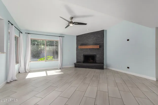 a view of an empty room with a fireplace and a window