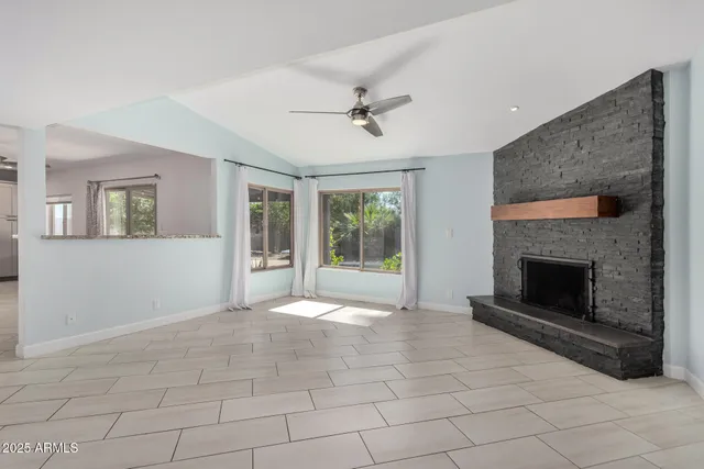 a view of an empty room with a fireplace and a window