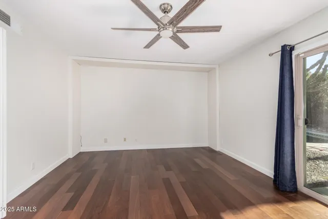 an empty room with a window and a ceiling fan