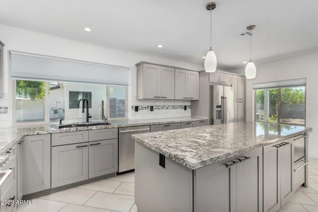 a kitchen with granite countertop kitchen island a sink appliances and a counter space