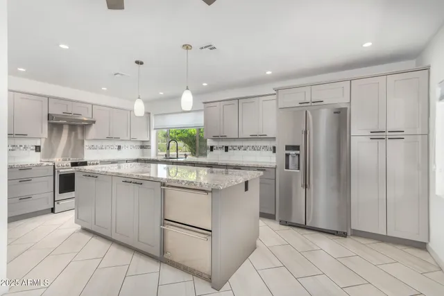 a kitchen with kitchen island granite countertop appliances cabinets and a sink