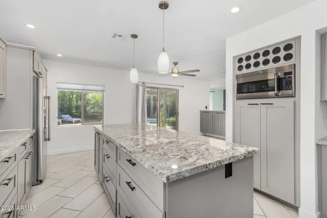 a kitchen with kitchen island a sink stainless steel appliances and window