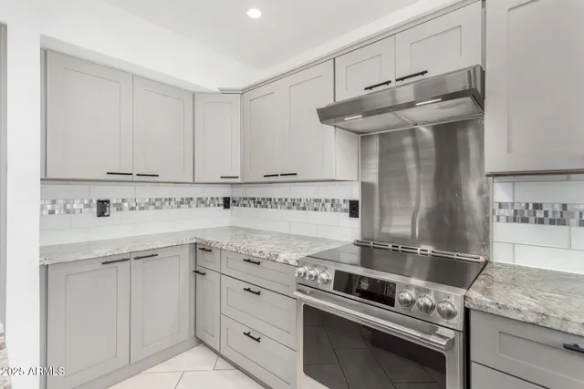 a kitchen with stainless steel appliances granite countertop a sink and a stove