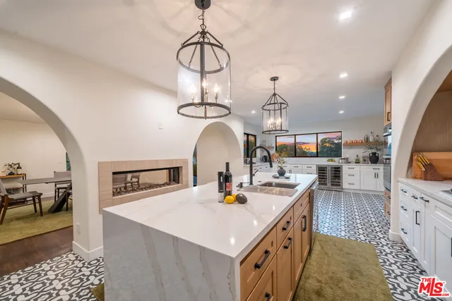 a living room with furniture a flat screen tv and kitchen view