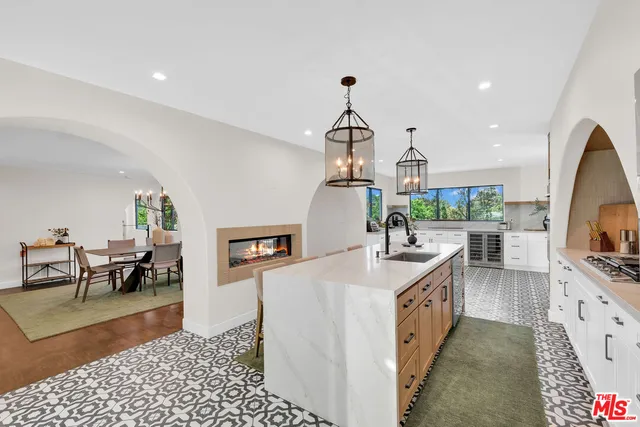 a kitchen with stainless steel appliances granite countertop a refrigerator a sink and a stove