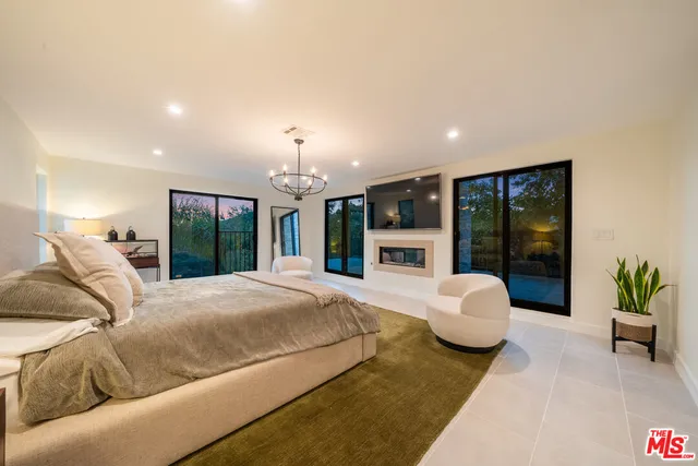 a bedroom with a bed and large windows