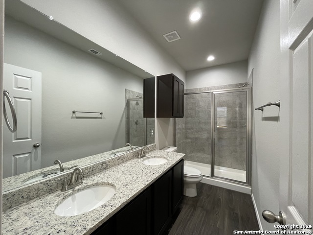 616 Grayson Lane Seguin, TX 78155 - Photo 12 of 17 a bathroom with a granite countertop sink a toilet a mirror and shower