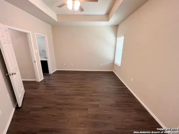 an empty room with wooden floor and staircase