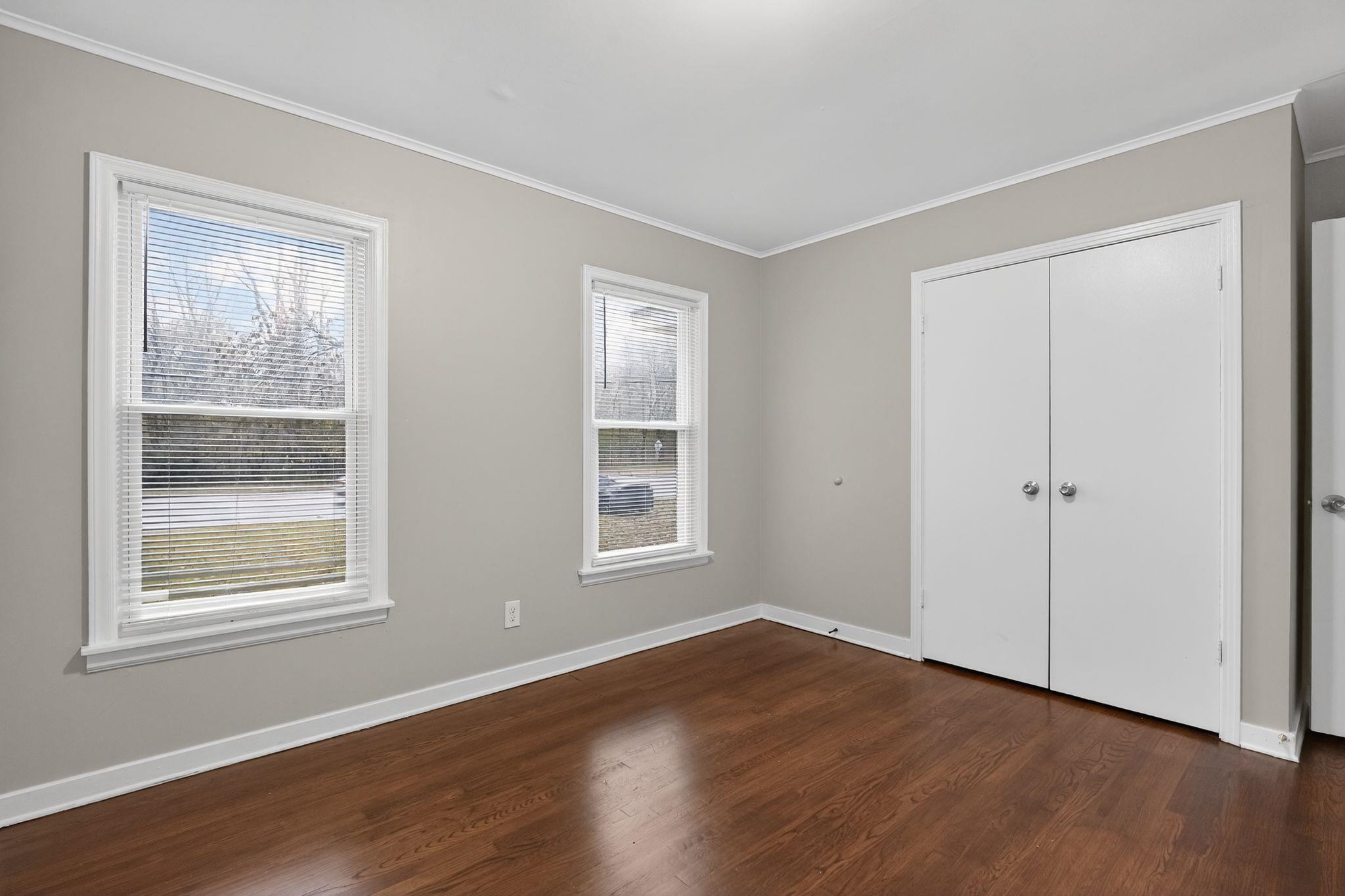177 East Raines Road Memphis, TN 38109 - Photo 19 of 32 Unfurnished bedroom with ornamental molding, dark wood-style flooring, and a closet