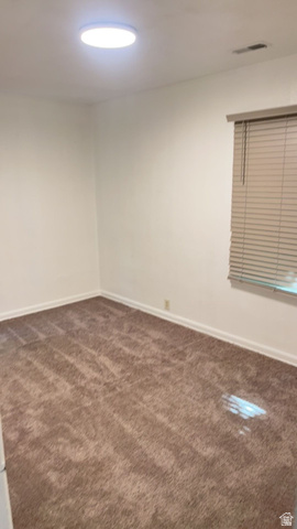 408 North 200 West Logan, UT 84321 - Photo 18 of 18 Brown carpeted flooring with white baseboards, a window with horizontal blinds, and a flush-mount ceiling light fixture