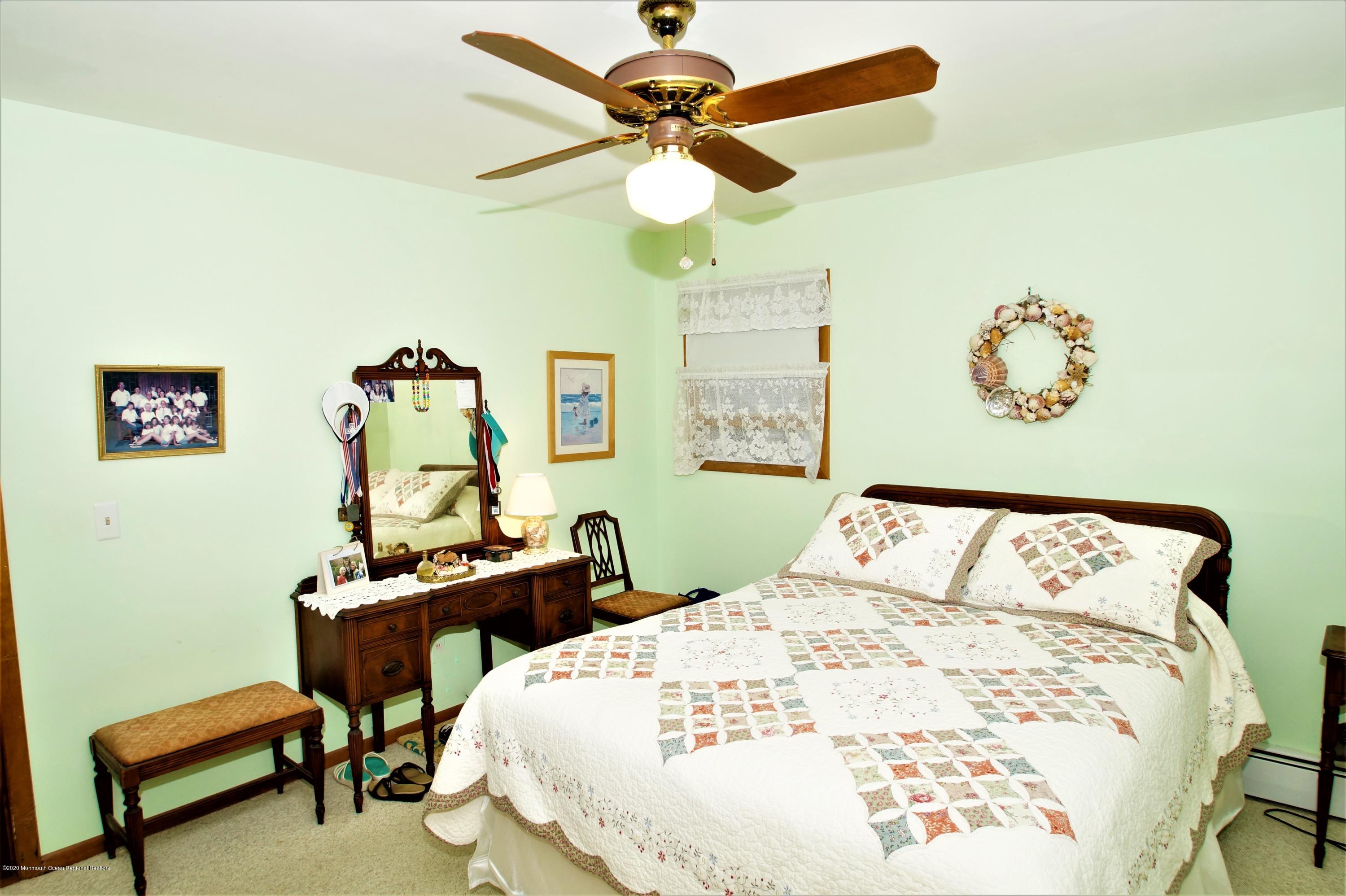 63 Mizzen Road Brick, NJ 08723 - Photo 23 of 37 a bedroom with a bed and a chandelier