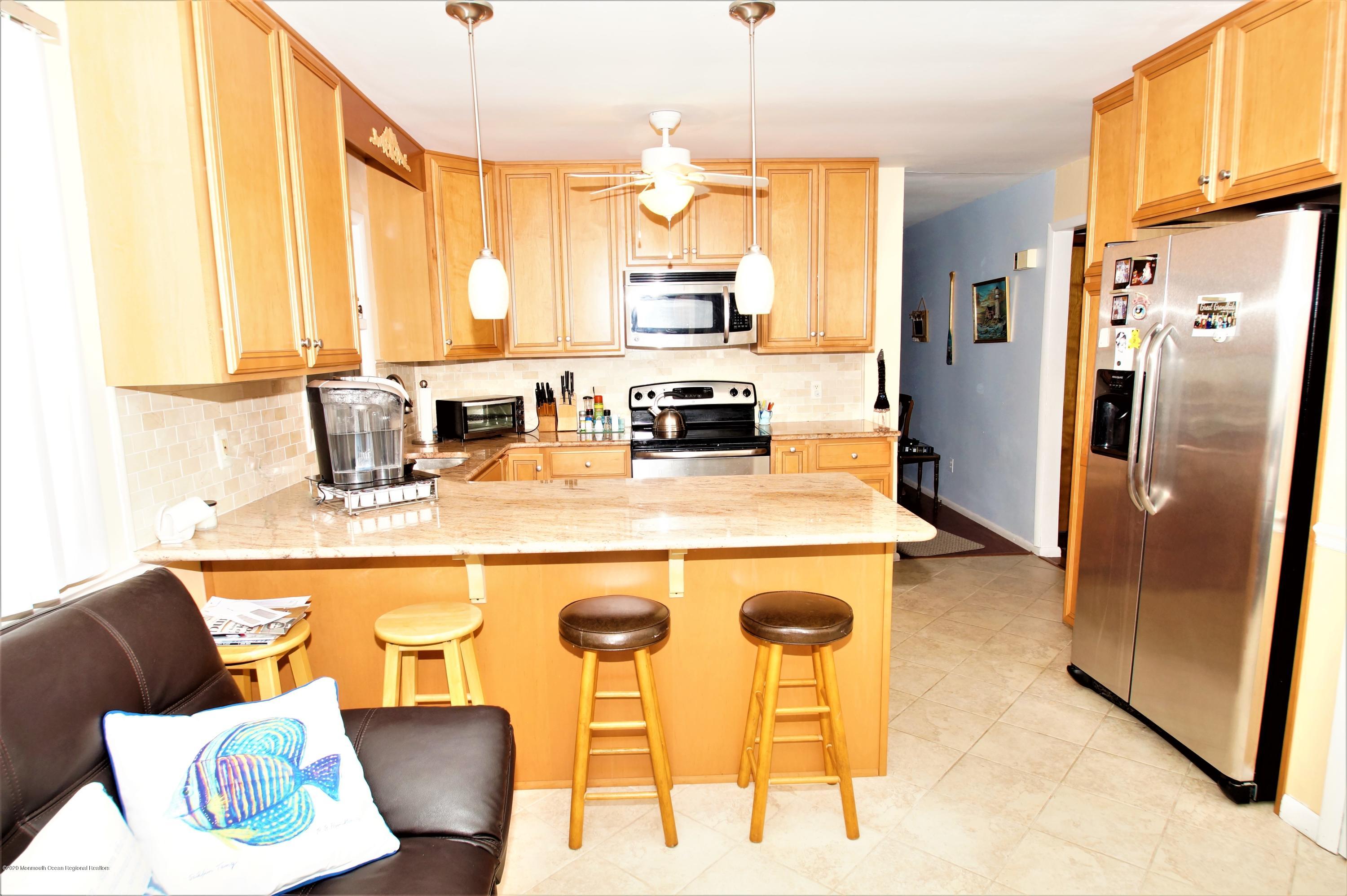 63 Mizzen Road Brick, NJ 08723 - Photo 9 of 37 a kitchen with stainless steel appliances granite countertop a refrigerator a stove and a microwave
