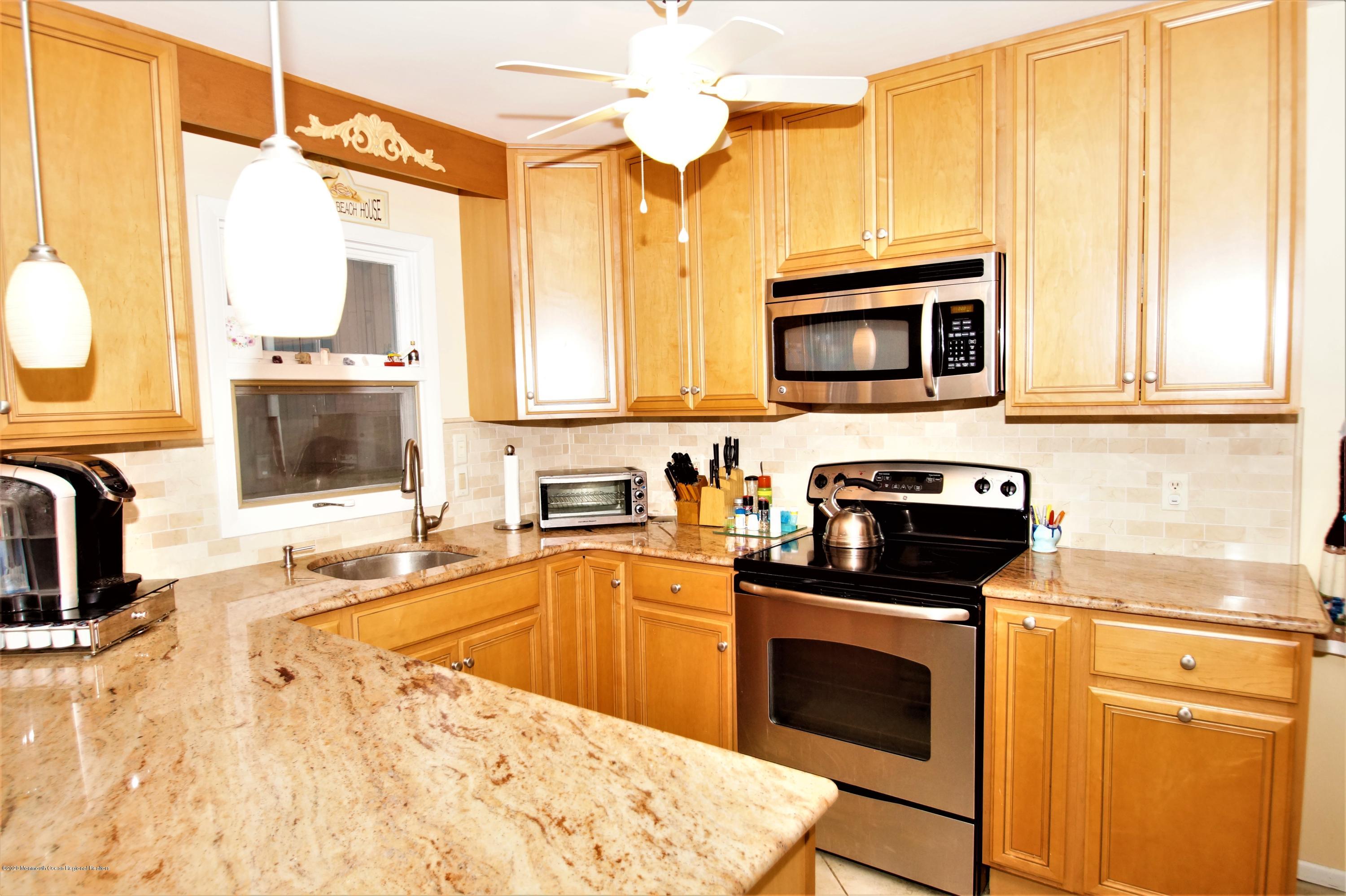 63 Mizzen Road Brick, NJ 08723 - Photo 10 of 37 a kitchen with stainless steel appliances granite countertop a stove a sink and a microwave
