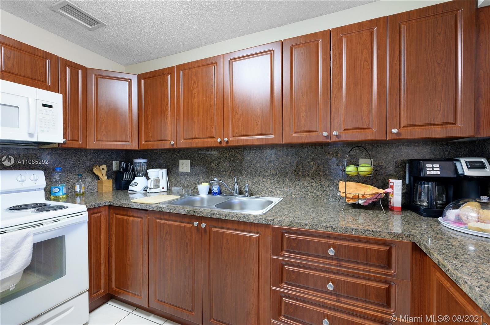 14468 Southwest 50th Terrace Miami, FL 33175 - Photo 5 of 15 a kitchen with stainless steel appliances granite countertop a stove a sink dishwasher and cabinets with wooden floor