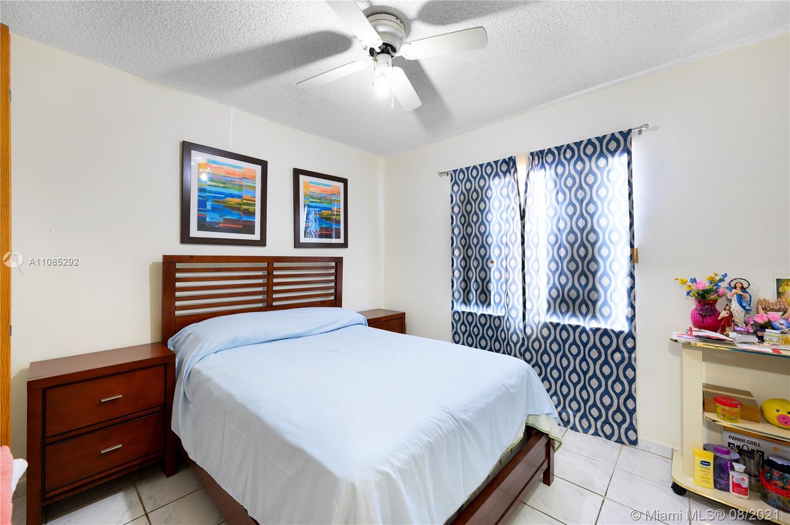 14468 Southwest 50th Terrace Miami, FL 33175 - Photo 8 of 15 a bedroom with a bed and a chandelier