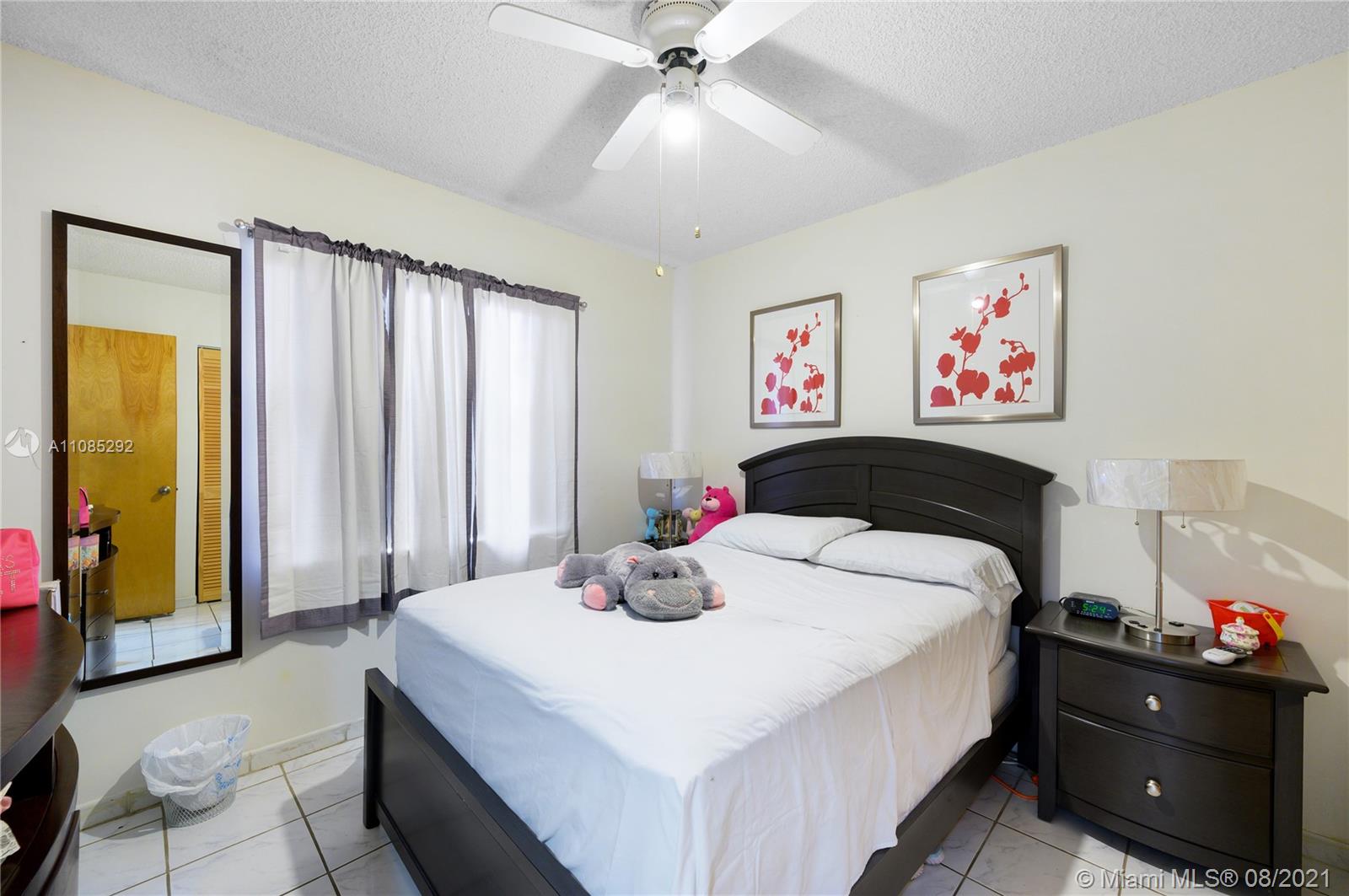 14468 Southwest 50th Terrace Miami, FL 33175 - Photo 9 of 15 a bedroom with a bed and a chandelier
