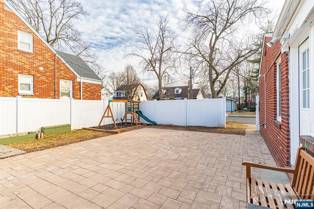 703 Elm Street Roselle, NJ 07203 - Photo 15 of 17 a backyard of a house with large trees and outdoor seating