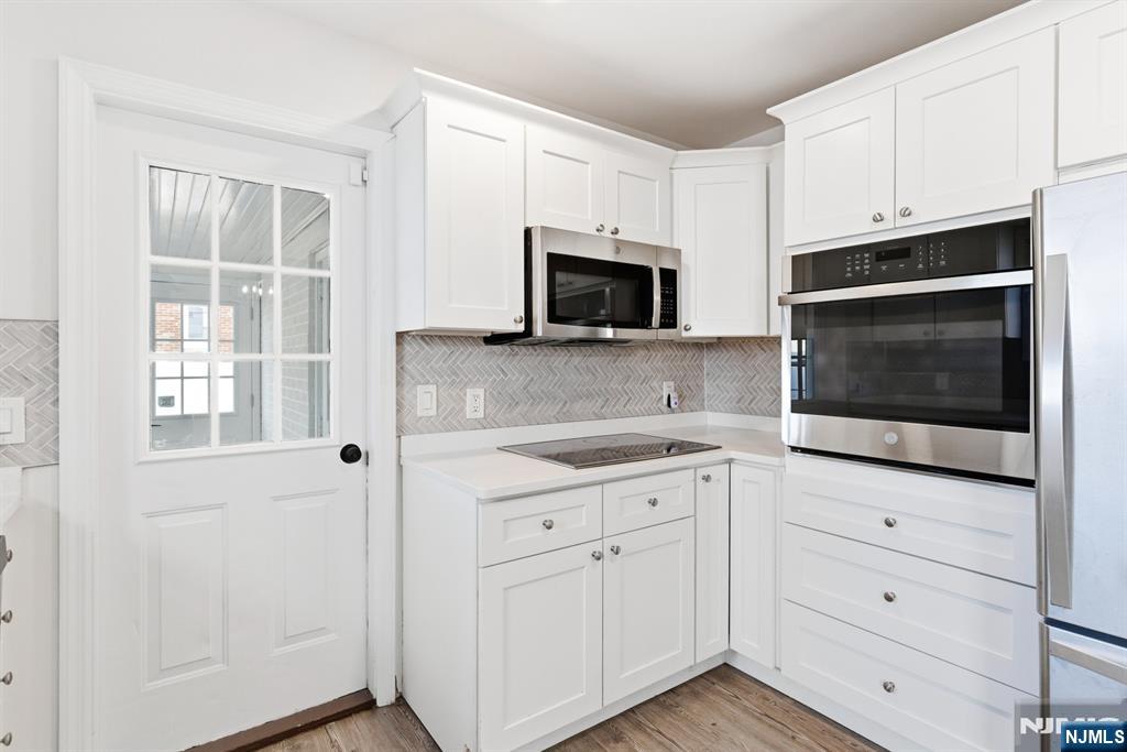 703 Elm Street Roselle, NJ 07203 - Photo 7 of 17 a kitchen with white cabinets appliances and a sink