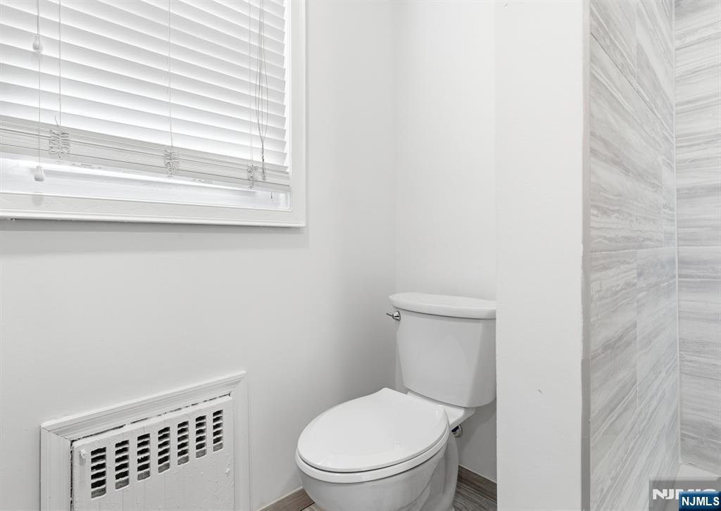703 Elm Street Roselle, NJ 07203 - Photo 9 of 17 a white toilet sitting next to a window