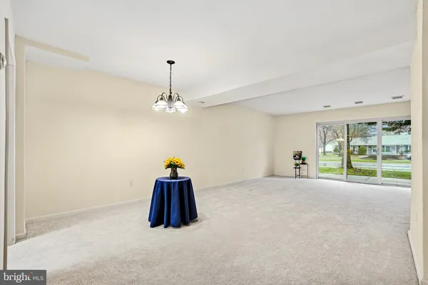 a big room with chandelier fan and windows