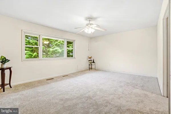 an empty room with a window and a fan