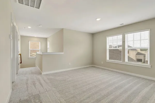 a view of empty room with wooden floor and window