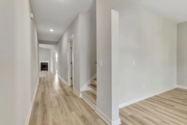 a view of a hallway with wooden floor and staircase