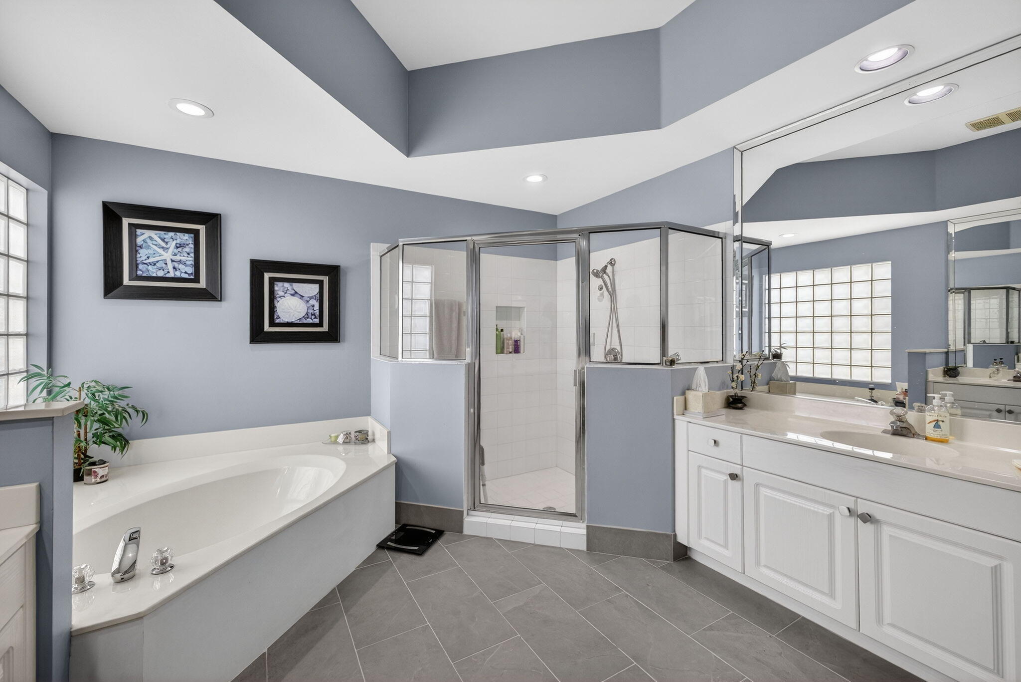 7669 Rockford Road Boynton Beach, FL 33472 - Photo 24 of 73 a spacious bathroom with a double vanity sink a large mirror and a bathtub