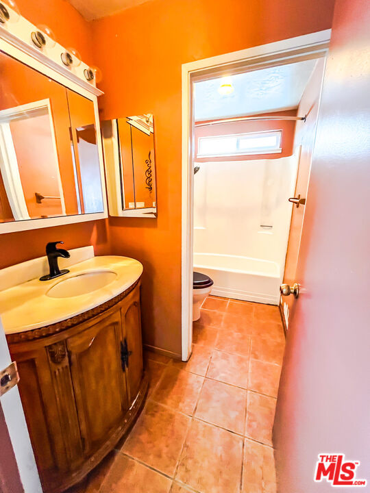 1001 South McCall Street Ridgecrest, CA 93555 - Photo 13 of 27 a bathroom with a granite countertop sink and a mirror