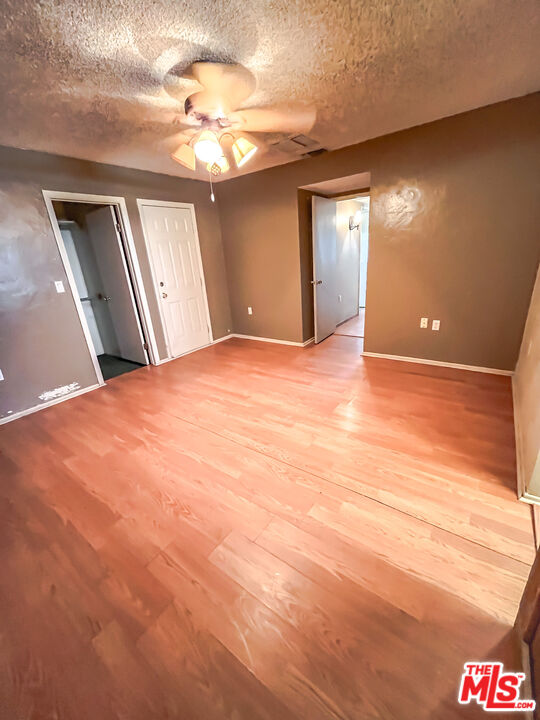 1001 South McCall Street Ridgecrest, CA 93555 - Photo 19 of 27 a view of an empty room with windows and a ceiling fan
