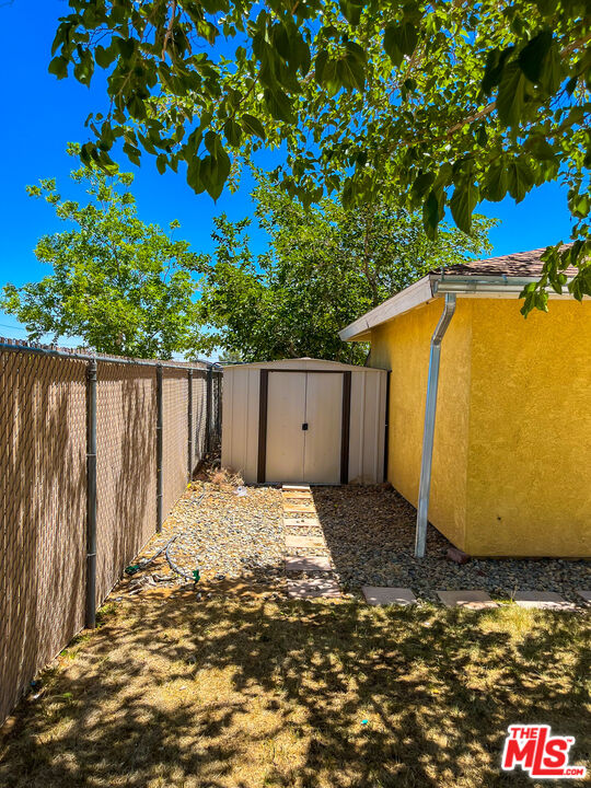 1001 South McCall Street Ridgecrest, CA 93555 - Photo 26 of 27 a backyard of a house with a bench and wooden fence