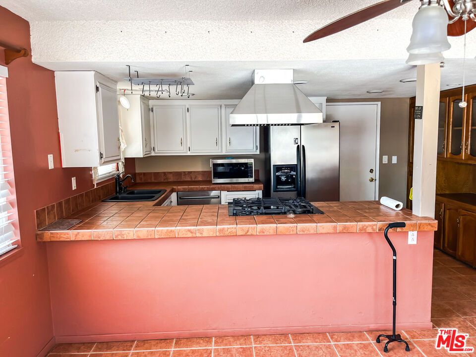 1001 South McCall Street Ridgecrest, CA 93555 - Photo 6 of 27 a kitchen with stainless steel appliances granite countertop a stove a sink and a refrigerator