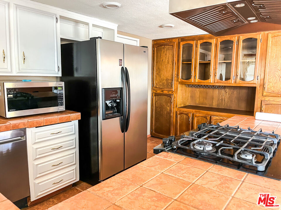 1001 South McCall Street Ridgecrest, CA 93555 - Photo 7 of 27 a kitchen with stainless steel appliances a refrigerator and a stove