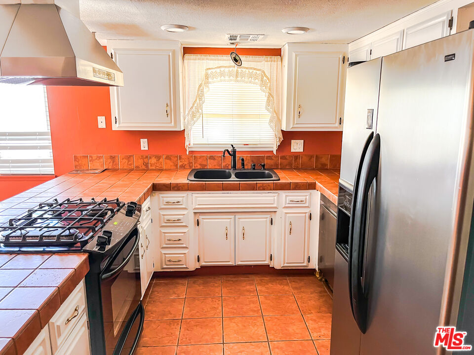 1001 South McCall Street Ridgecrest, CA 93555 - Photo 9 of 27 a kitchen with a sink stove and refrigerator