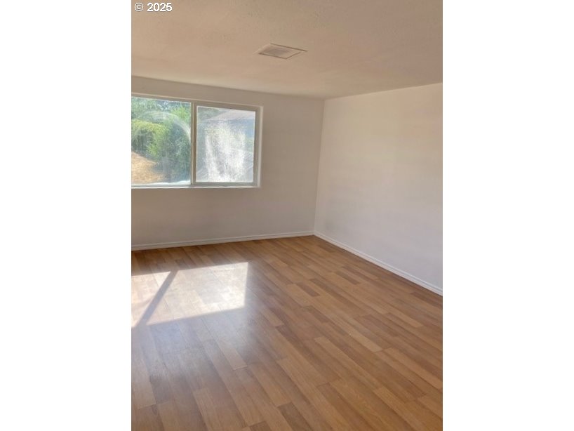 727 Southwest 28th Street Pendleton, OR 97801 - Photo 5 of 12 a view of an empty room with wooden floor and a window