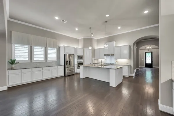 a view of an empty room with wooden floor fireplace and a window