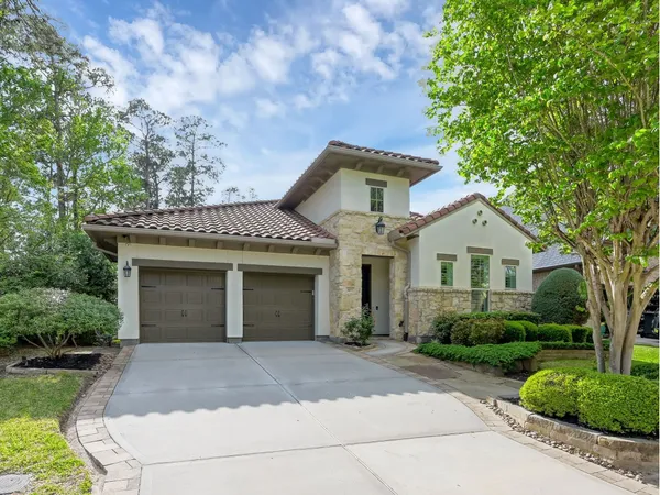 a front view of a house with a yard and trees