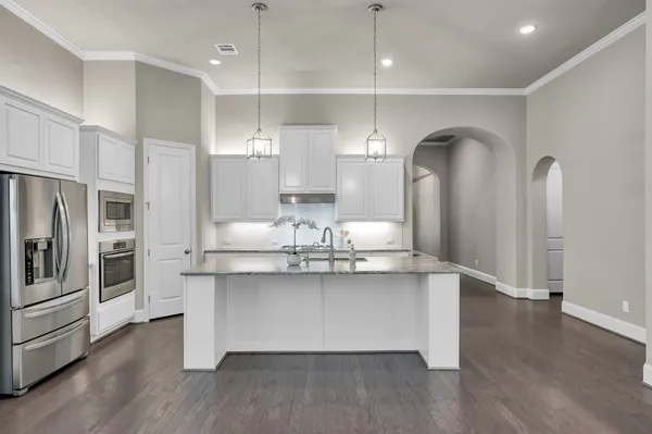 a kitchen with stainless steel appliances granite countertop a sink a stove and a refrigerator