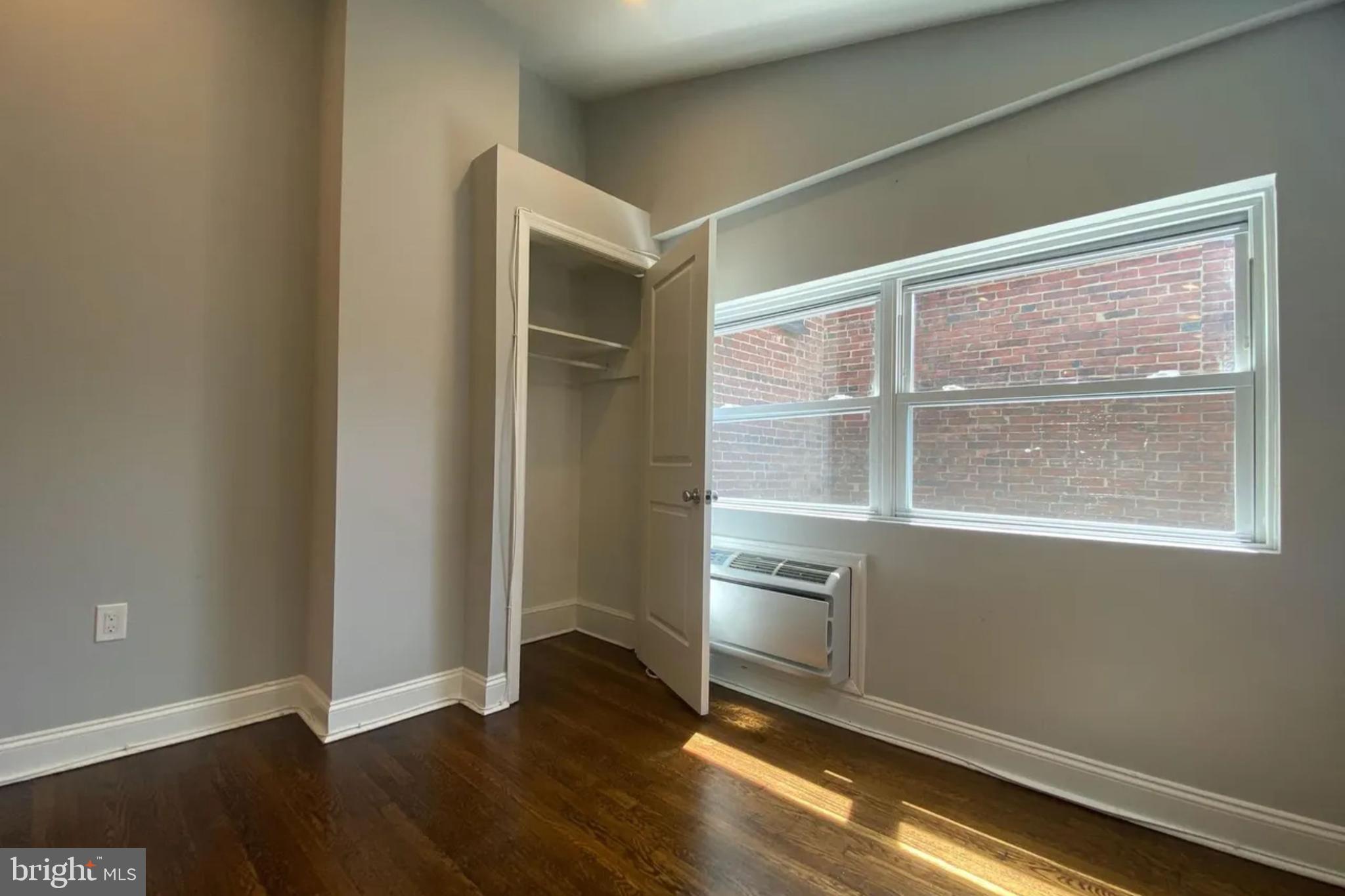 1616 Spruce Street, Unit 3R Philadelphia, PA 19103 - Photo 3 of 9 an empty room with wooden floor cabinet and windows