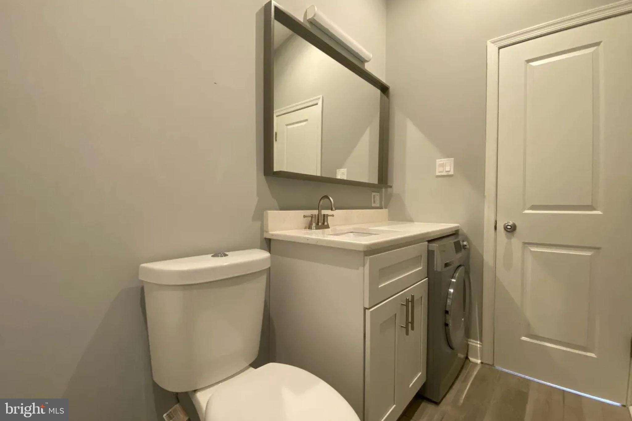 1616 Spruce Street, Unit 3R Philadelphia, PA 19103 - Photo 4 of 9 a bathroom with a toilet sink and mirror