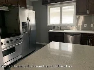 a kitchen with stainless steel appliances a refrigerator a stove a sink a washer and dryer