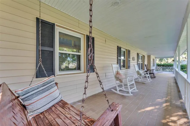 a view of a patio with table and chairs with wooden floor and fence