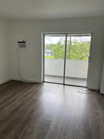 a view of a room with wooden floor and window