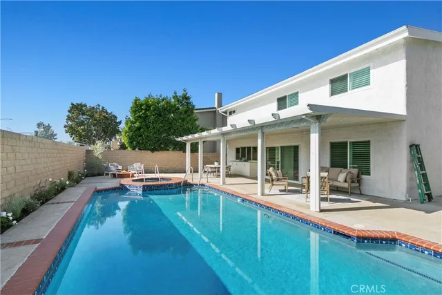 a view of a house with swimming pool and sitting area