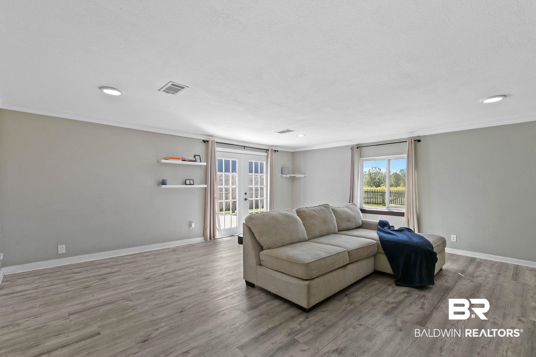 16796 Thompson Road Loxley, AL 36551 - Photo 24 of 93 Living area with healthy amount of natural light, french doors, light wood-type flooring, crown molding, and recessed lighting