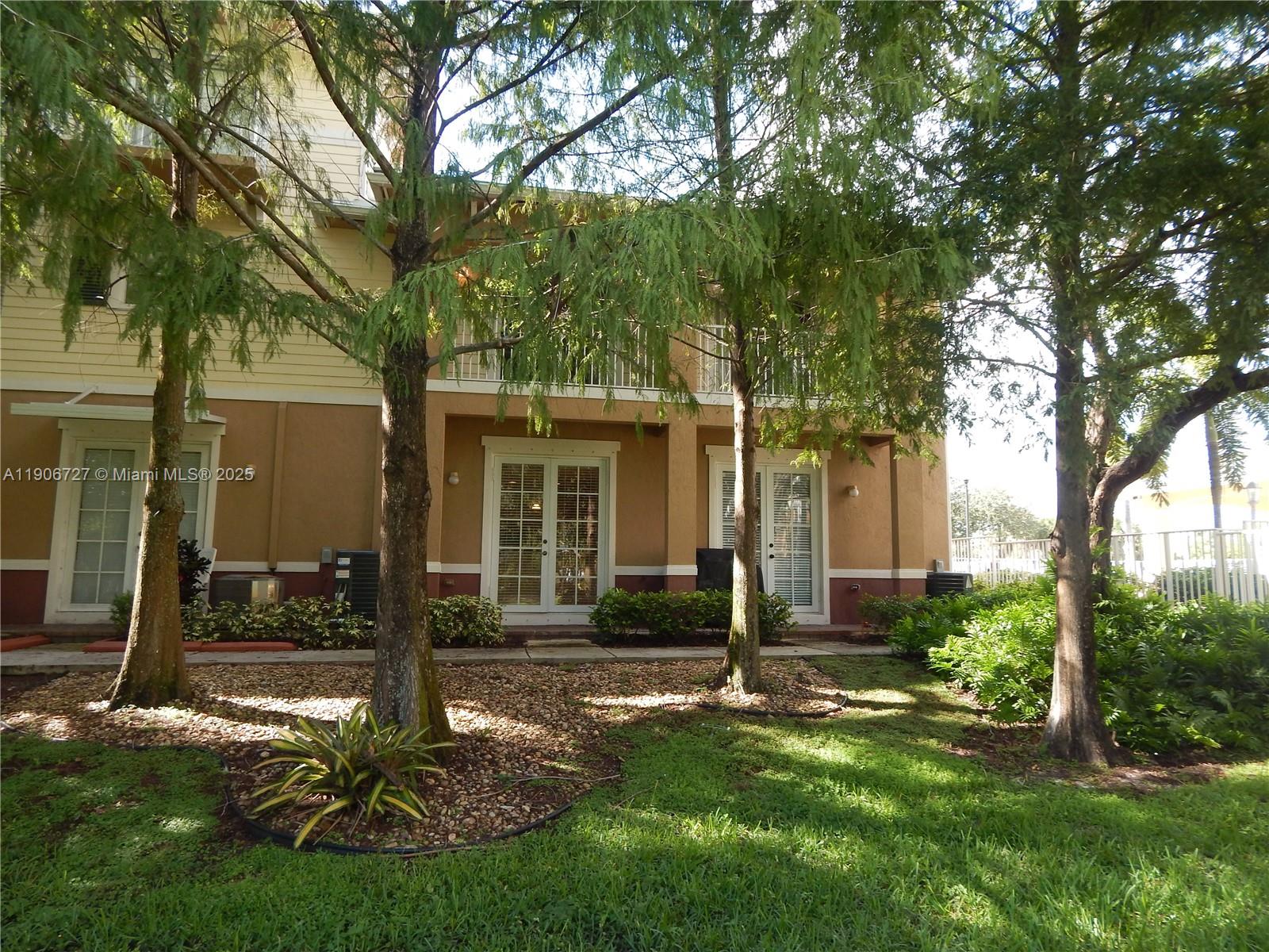 4622 Southwest 75th Way, Unit 102 Davie, FL 33314 - Photo 15 of 16 a front view of a house with a yard