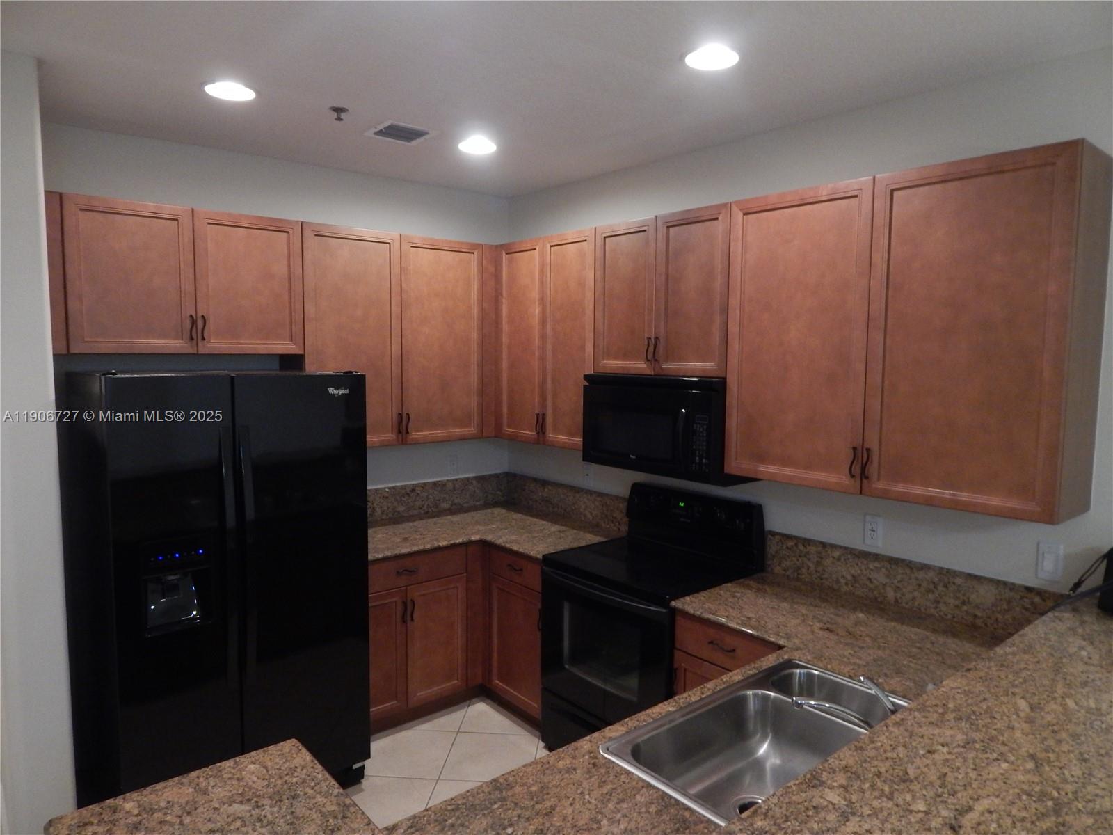 4622 Southwest 75th Way, Unit 102 Davie, FL 33314 - Photo 2 of 16 a kitchen with a refrigerator and a stove