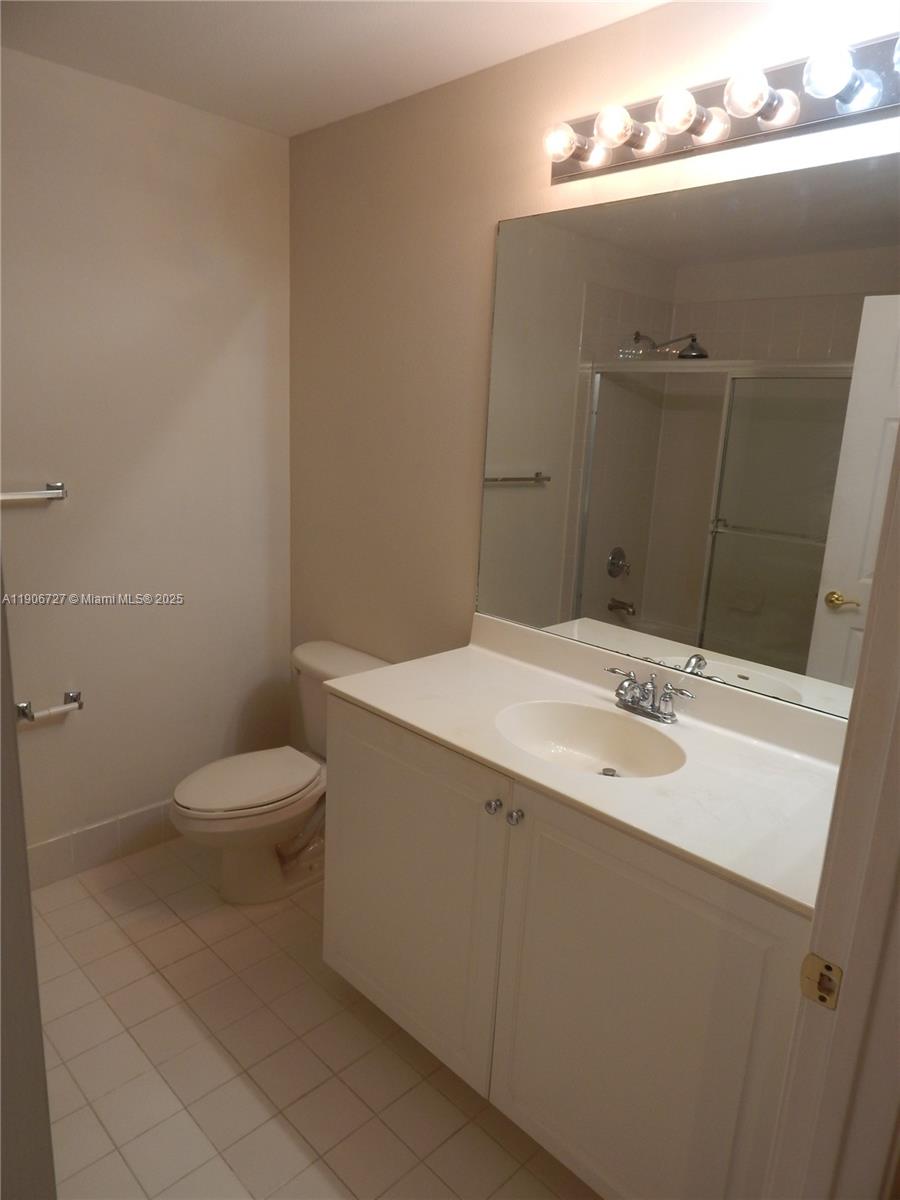 4622 Southwest 75th Way, Unit 102 Davie, FL 33314 - Photo 6 of 16 a bathroom with a toilet sink and mirror