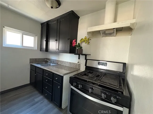 a view of kitchen island wooden floor and stainless steel appliances