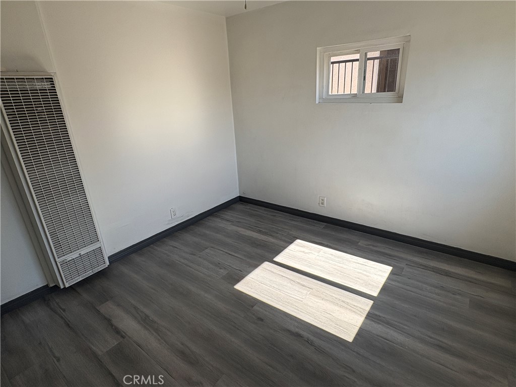 9148 Verner Street, Unit A Pico Rivera, CA 90660 - Photo 8 of 14 a view of an empty room with wooden floor and a window